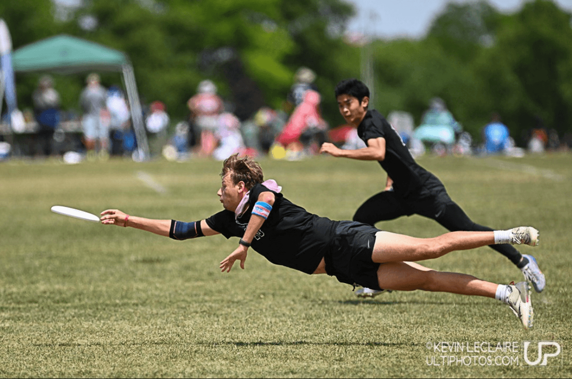 Ultimate Frisbee athlete laying out for a disc