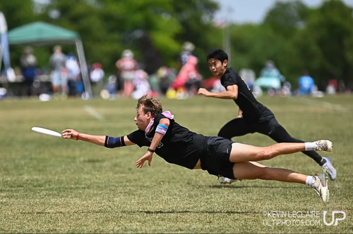 Ultimate Frisbee athlete laying out for a disc
